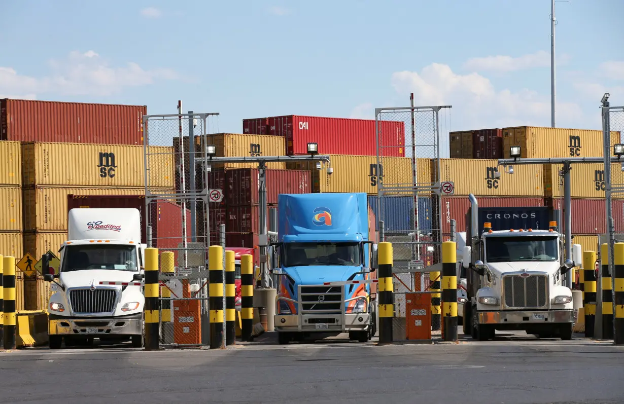 Trucks loaded with shipping containers leave the Port of Montreal