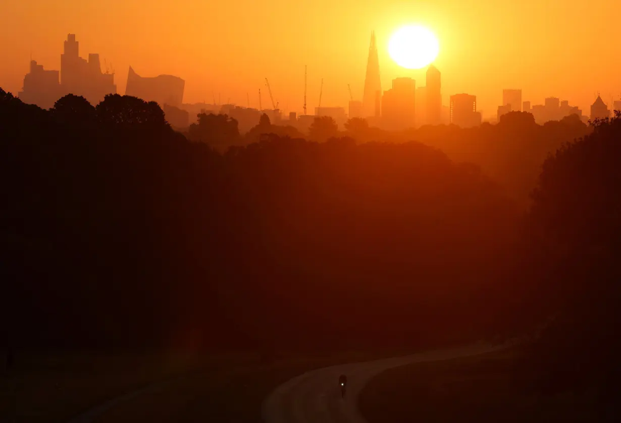 FILE PHOTO: Sun rises above the city skyline during hot weather, in London