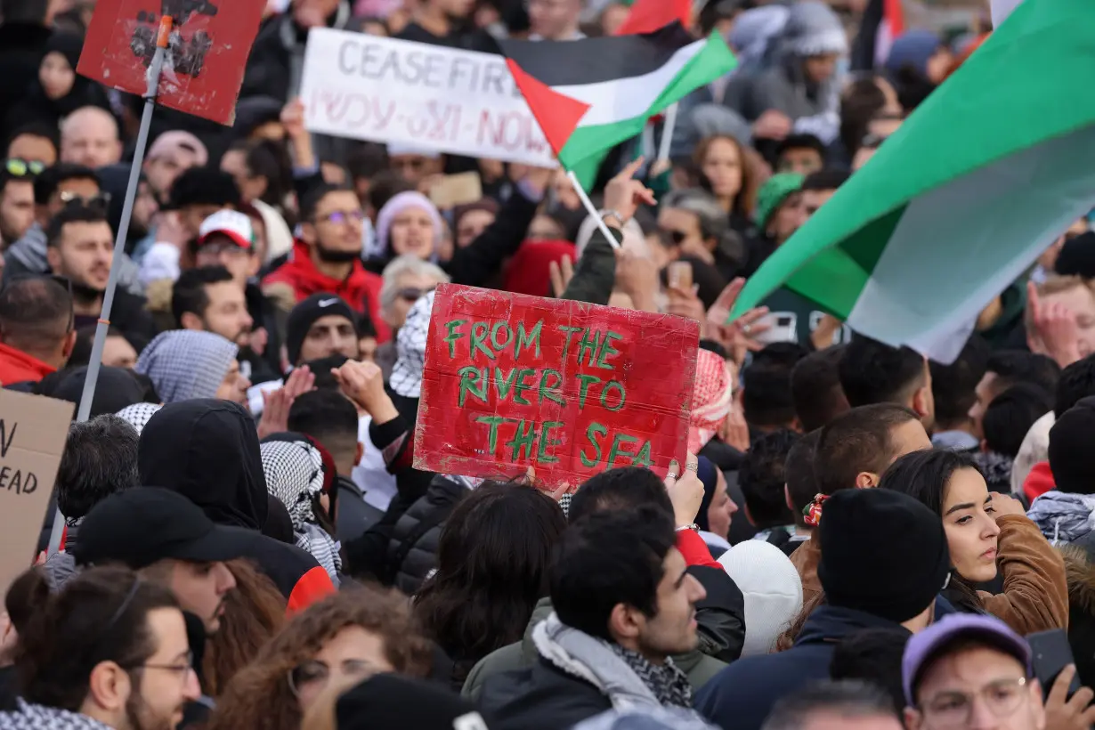 People, including one holding up a sign that reads: 