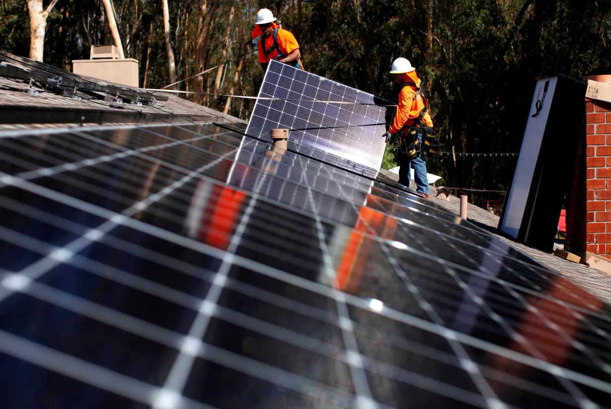 FILE PHOTO: Solar installers from Baker Electric place solar panels on the roof of a residential home in Scripps Ranch, San Diego, California