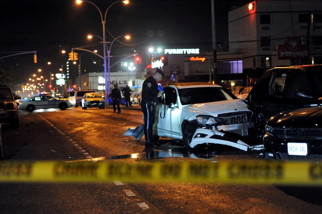 FILE PHOTO: A New York City police officer inspects cars at a crash site in the Brooklyn borough in New York