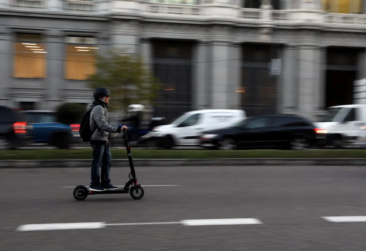 A man rides an electric scooter in Madrid