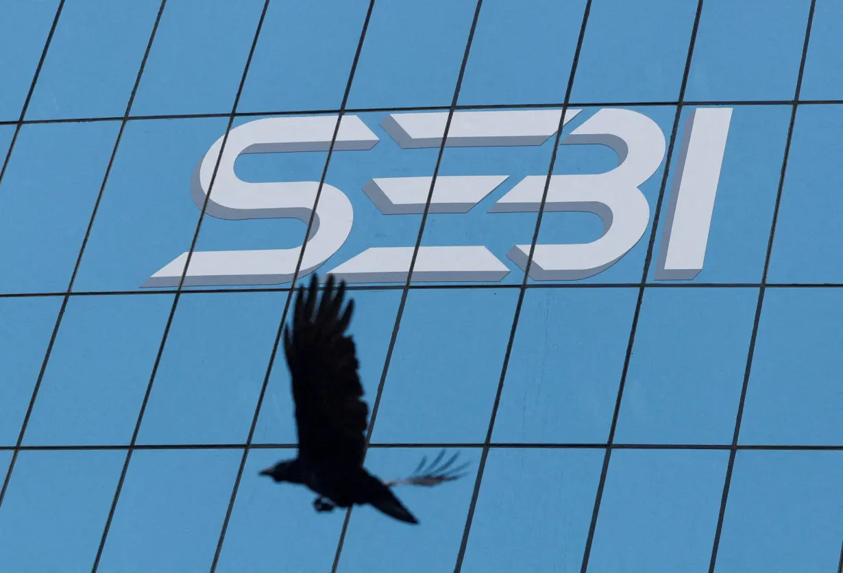 FILE PHOTO: A bird flies past the new logo of the Securities and Exchange Board of India (SEBI) at its headquarters in Mumbai