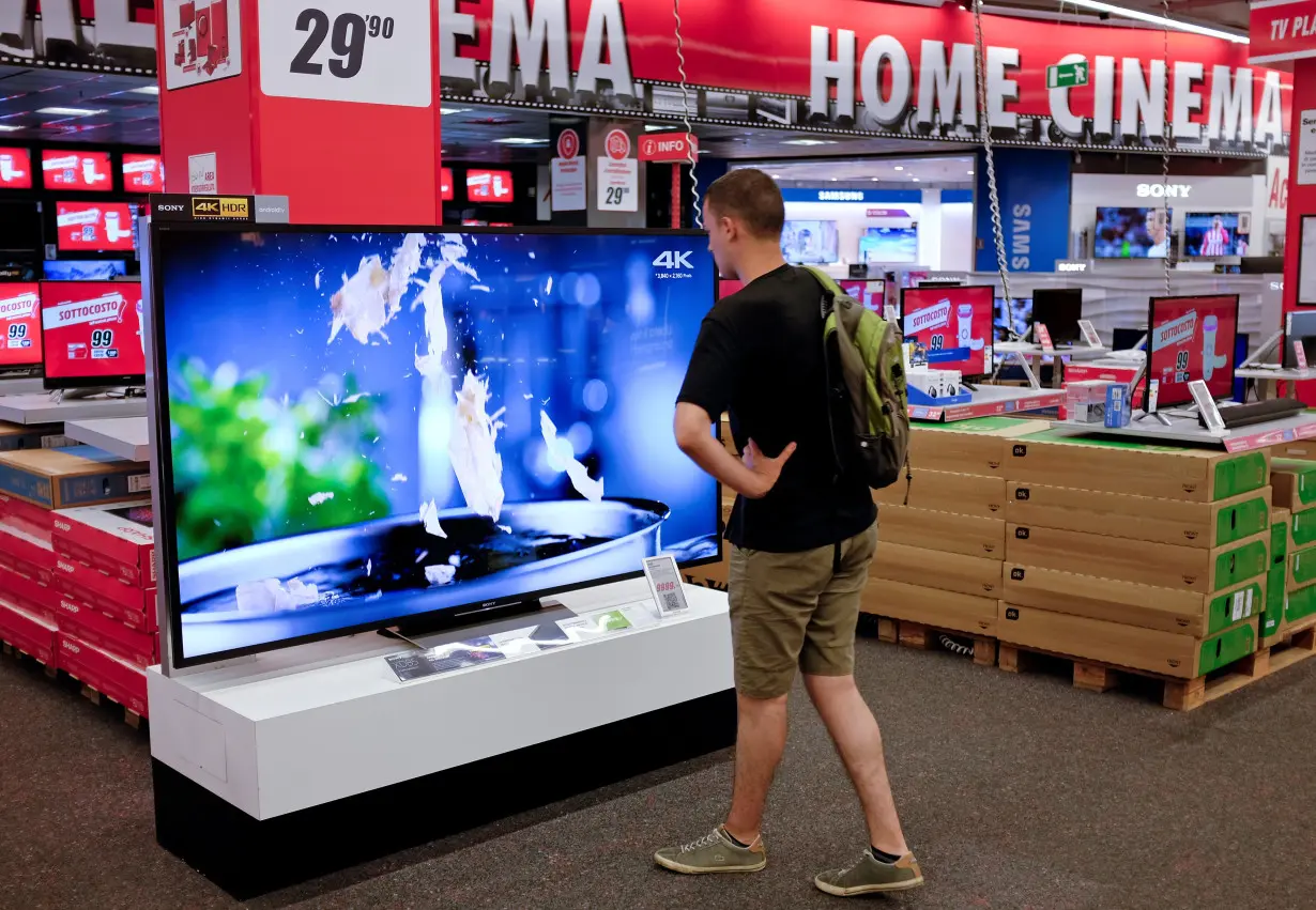 A man looks at a television in a mall in Rome