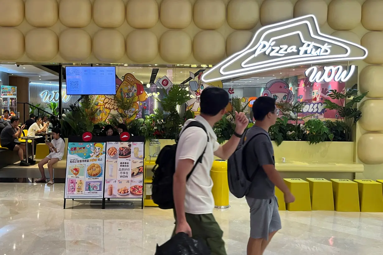 People walk past a Pizza Hut Wow restaurant at a shopping mall in Shenzhen