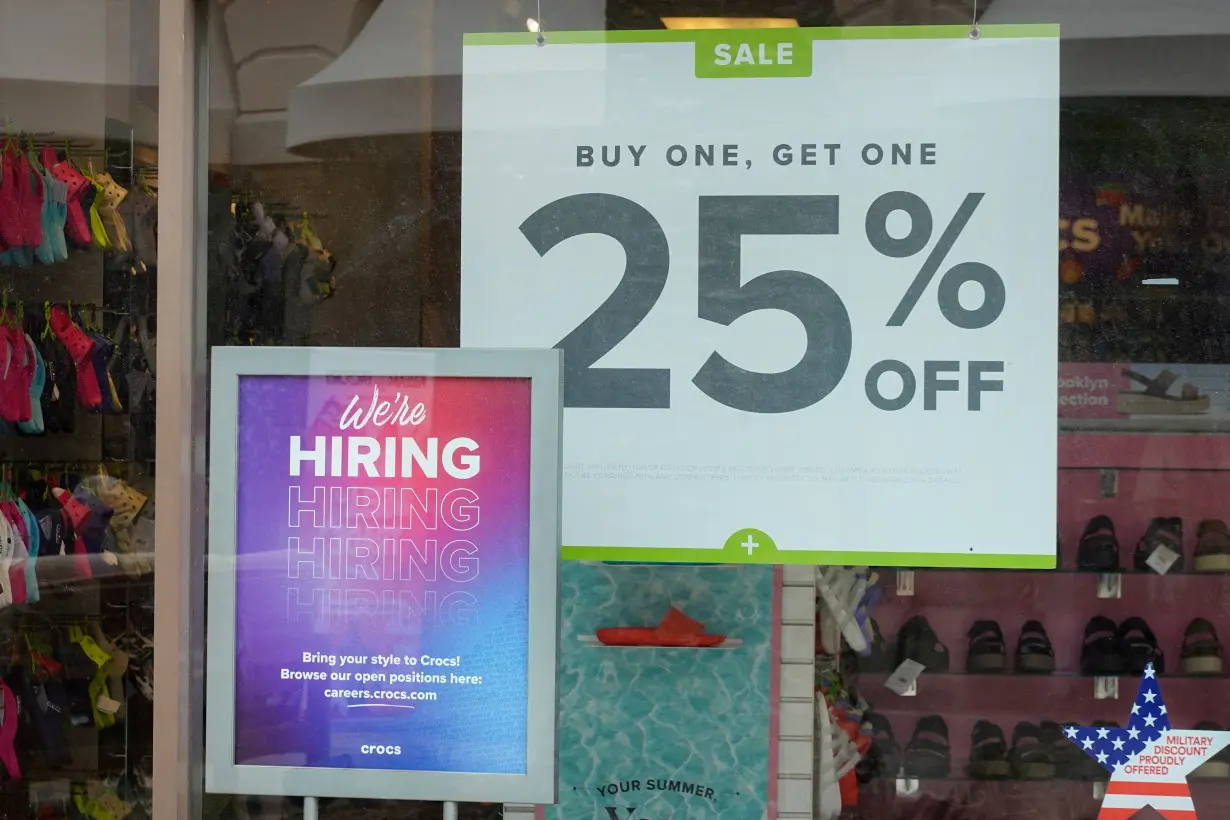 FILE PHOTO: Employment sign and sale sign shown at retail store