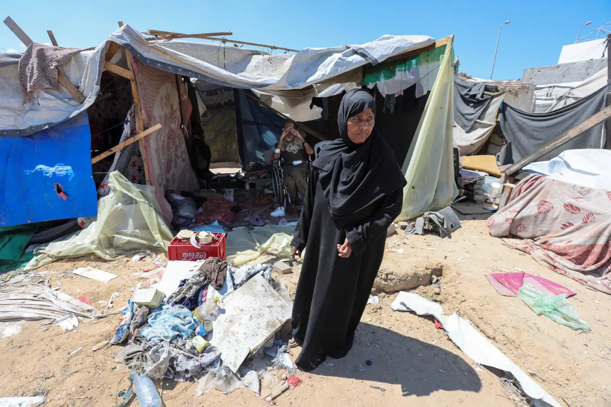 Displaced woman Iqbal Al-Zeidi stands in front of her tent which was torn by an Israeli strike, on the courtyard of Al-Aqsa Martyrs hospital, amid the Israel-Hamas conflict, in Deir Al-Balah