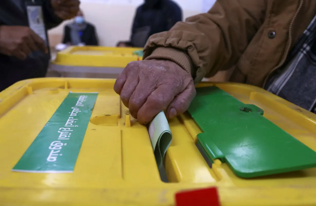 A voter casts a ballot to vote in the municipal and local governorate councils elections in Amman