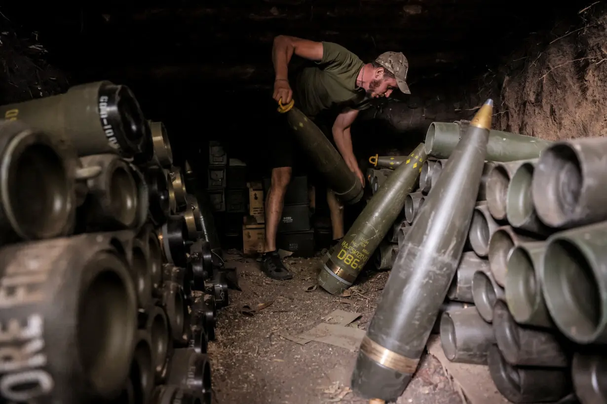 A Ukrainian serviceman prepares shells for a self-propelled howitzer at a frontline near the town of Chasiv Yar