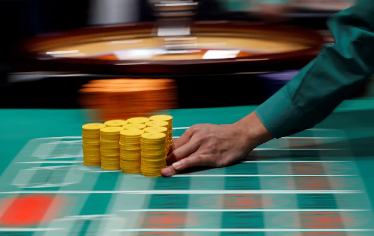 Instructor Daisuke Sato moves chips on a roulette table at Japan Casino School in Tokyo