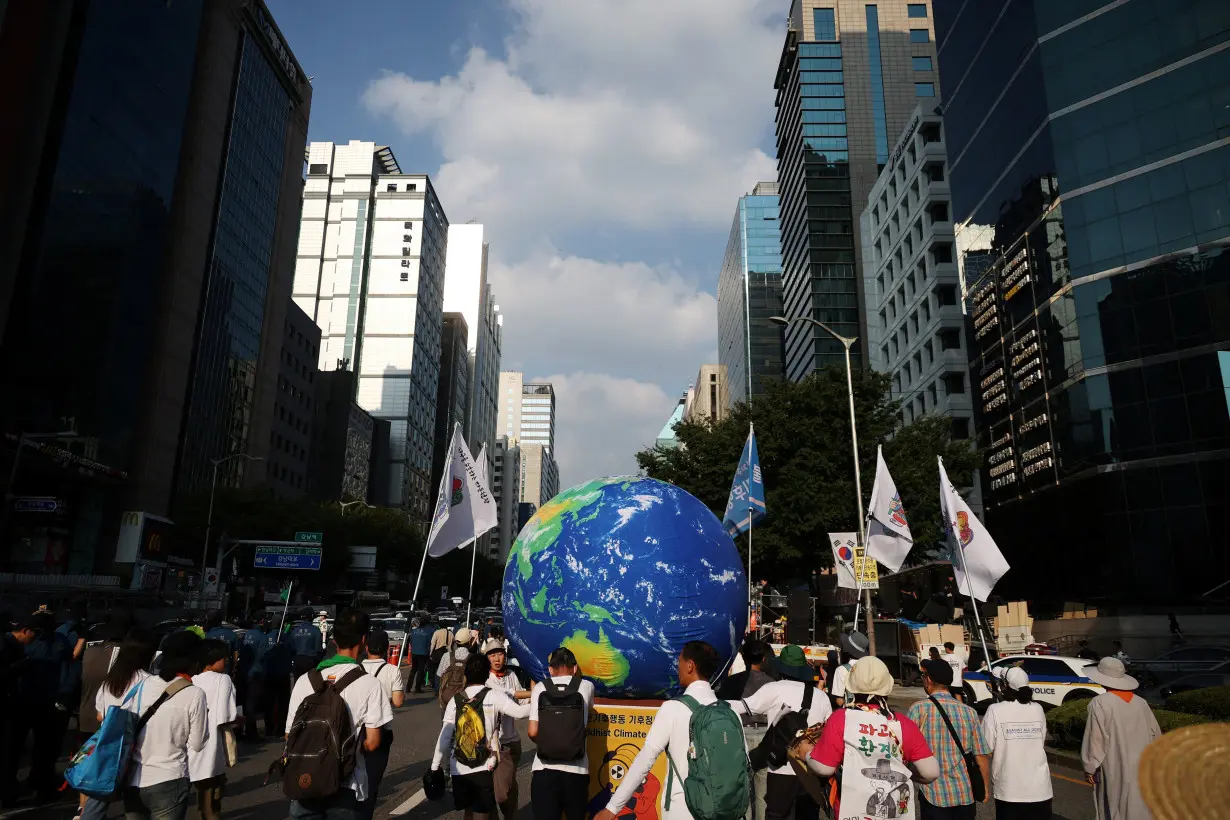 People take part in a climate justice rally in central Seoul