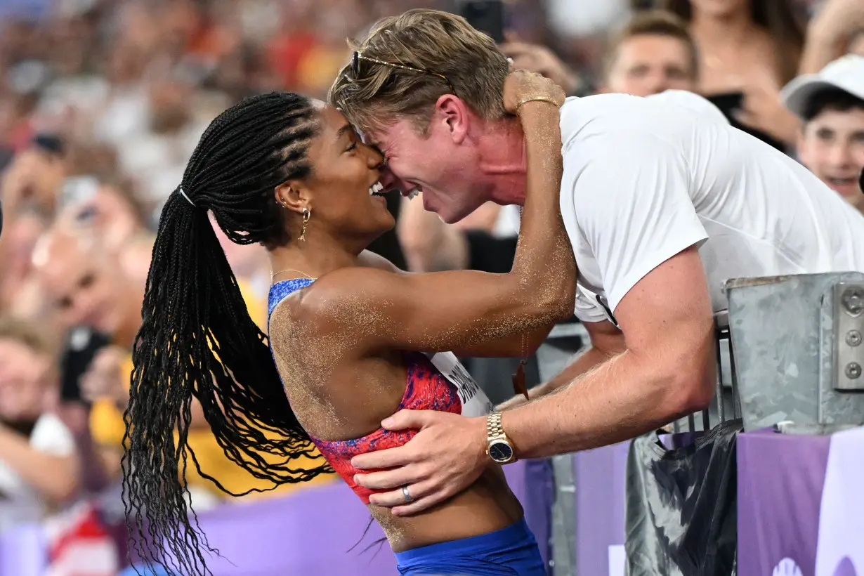 Tara Davis-Woodhall celebrates with her husband Hunter Woodhall after winning the Olympic title in the women's long jump at the 2024 Paris Games.