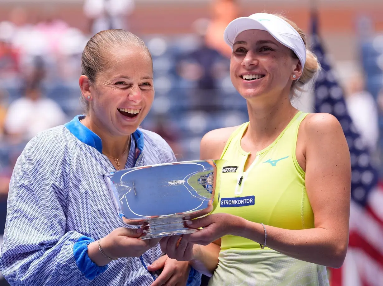 Lyudmyla Kichenok (right) and Jelena Ostapenko celebrate with the US Open trophy after winning the women's doubles final.