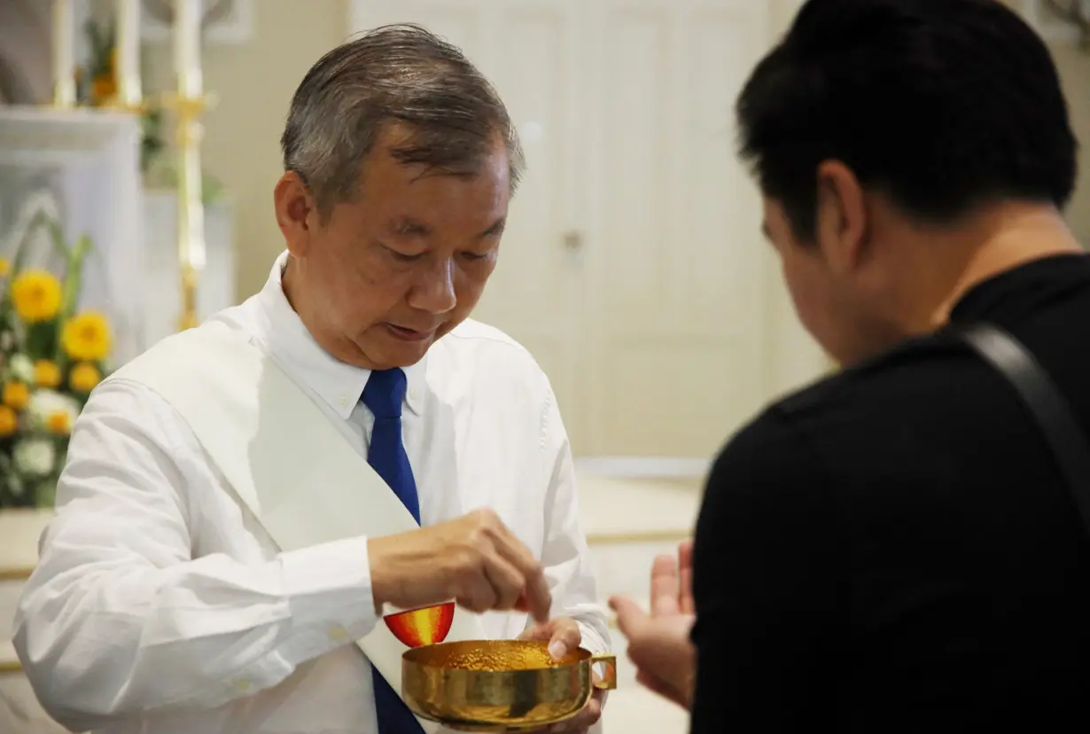 Raphael Lau serves as a communion minister during mass at the Cathedral of the Good Shepherd in Singapore