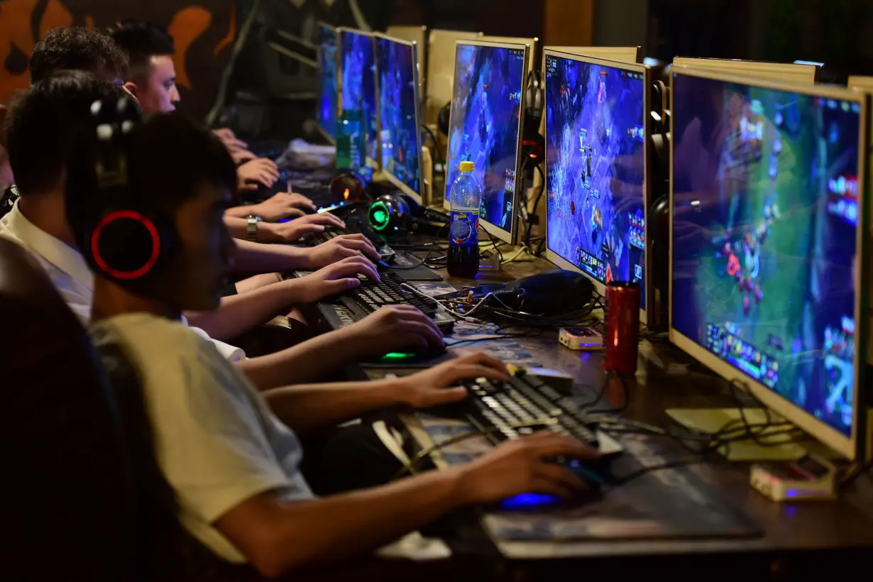 People play online games at an internet cafe in Fuyang