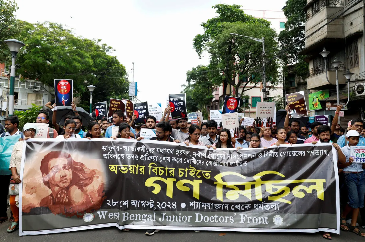 Members of the West Bengal Junior Doctors' Front march along a street during a protest condemning the rape and murder of a trainee medic at a government-run hospital, in Kolkata