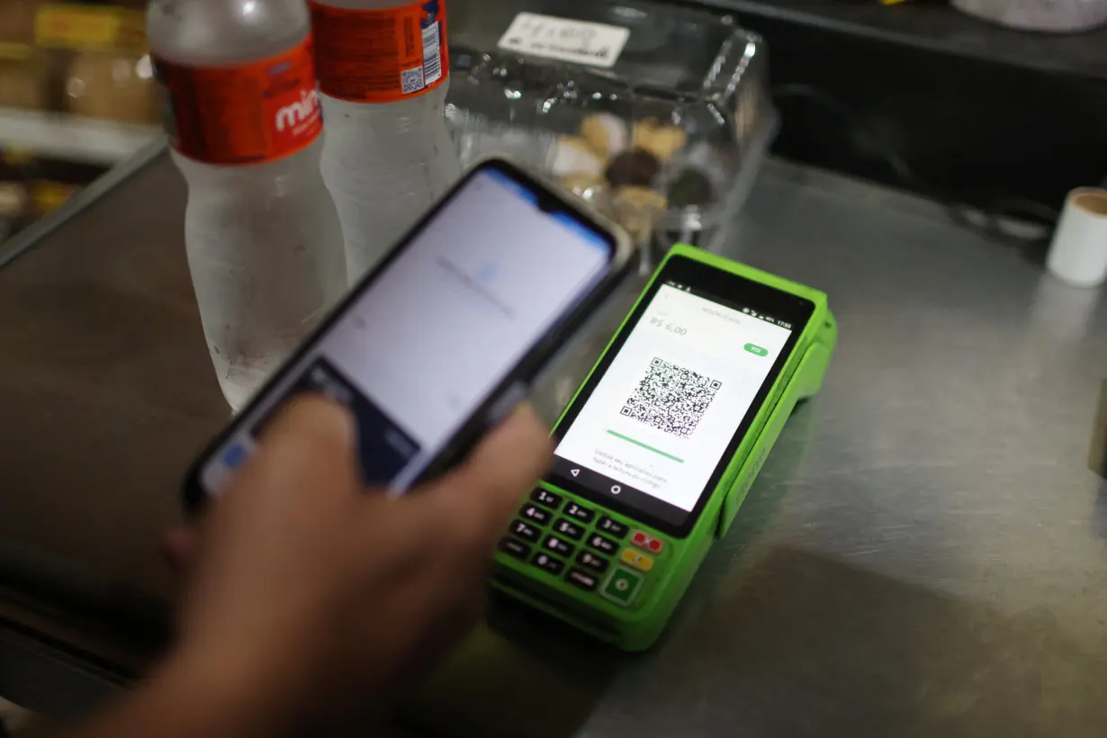 A person pays using their cell phone with the instant electronic payment mode known as PIX, at a store in Rio de Janeiro