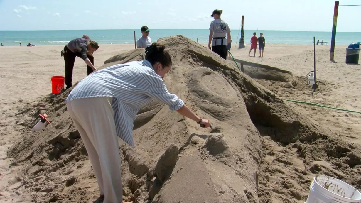 Giant beach sand sculpture created by expert, college students