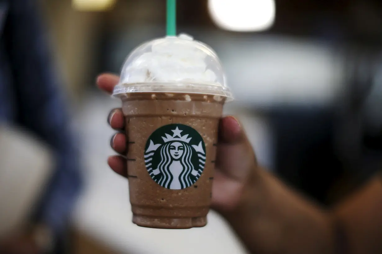 FILE PHOTO: A woman holds a Frappuccino at a Starbucks store inside the Tom Bradley terminal at LAX airport in Los Angeles