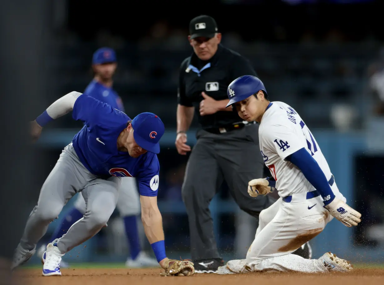 Shohei Ohtani of the Los Angeles Dodgers steals second base past Nico Hoerner of the Chicago Cubs.