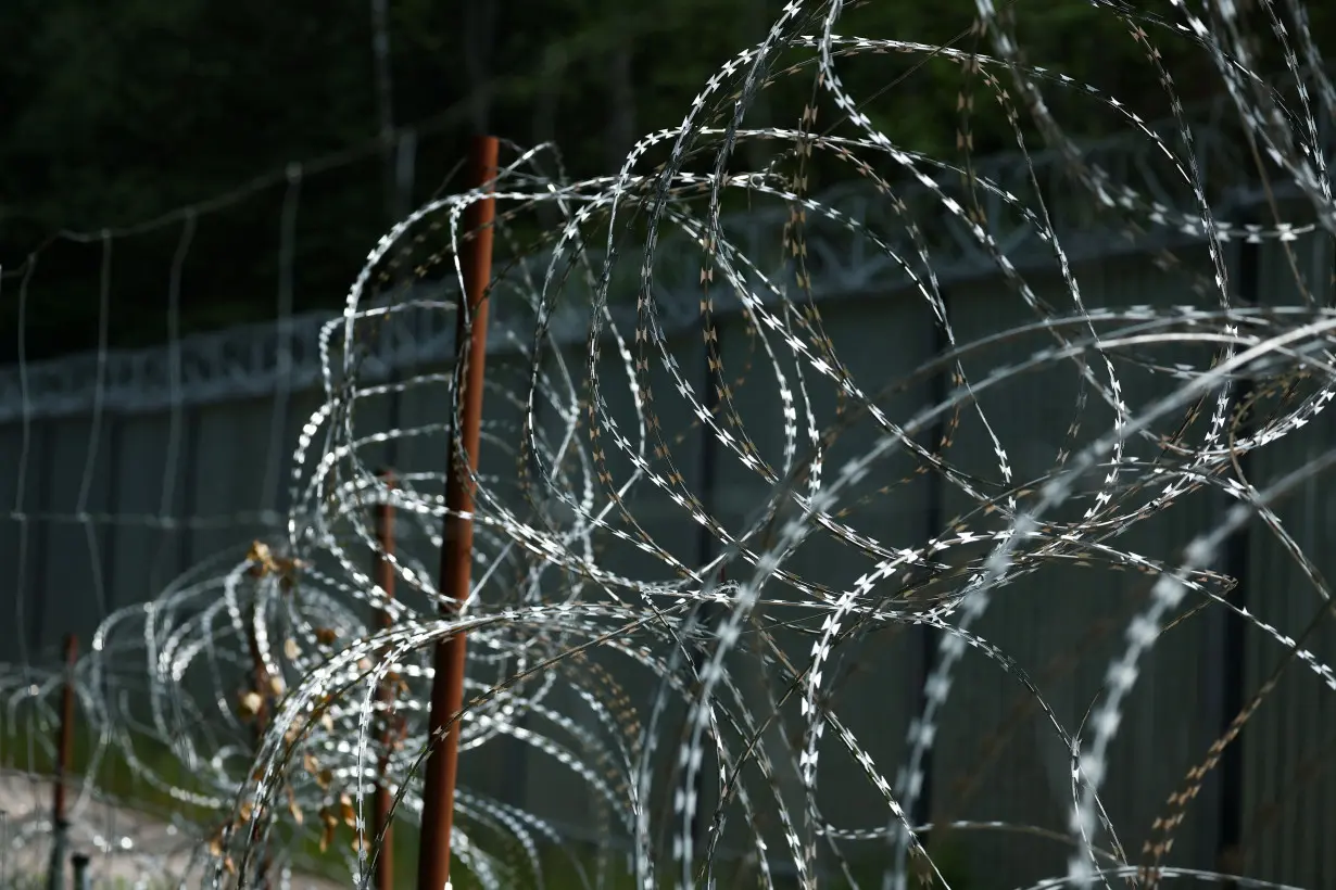 Razor wire is seen near the fence on Belarusian-Polish border in the forest near Topilo village