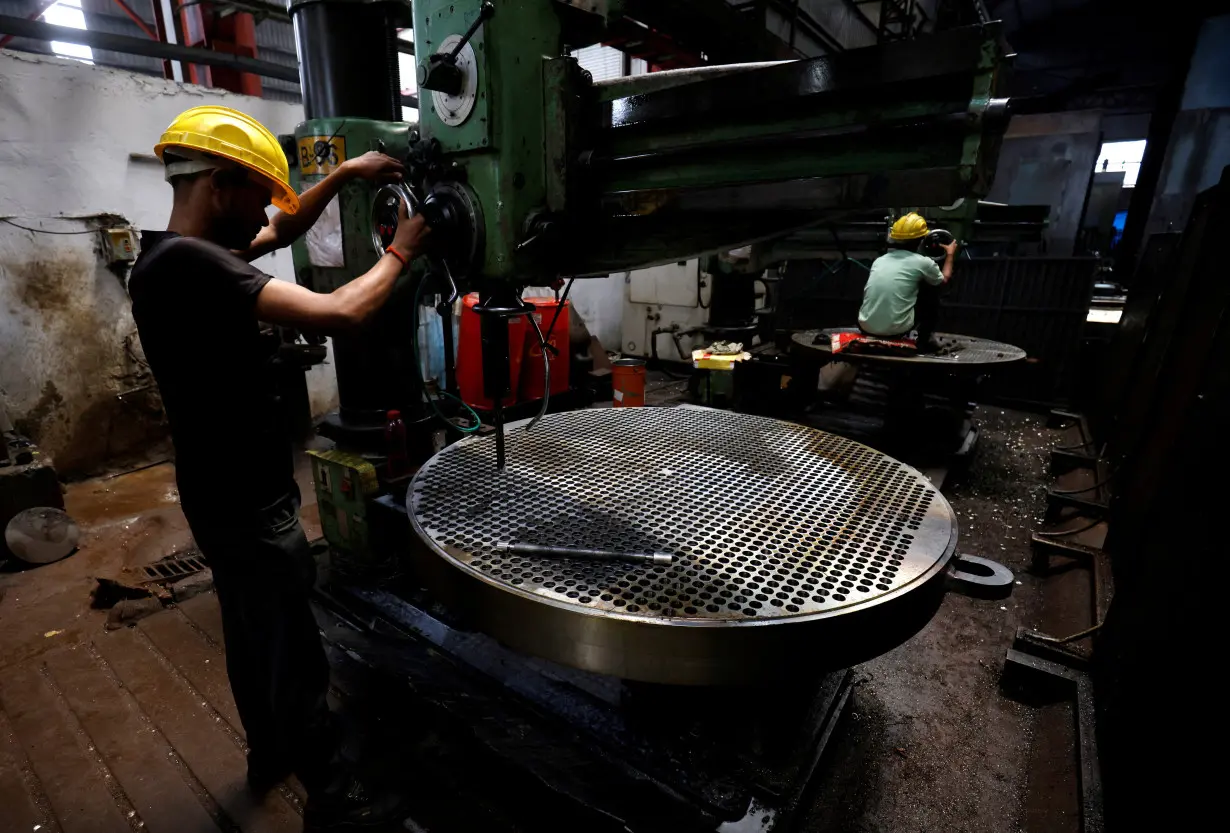 FILE PHOTO: FILE PHOTO: A worker makes a metal filter plate inside an industrial manufacturing unit on the outskirts of Ahmedabad