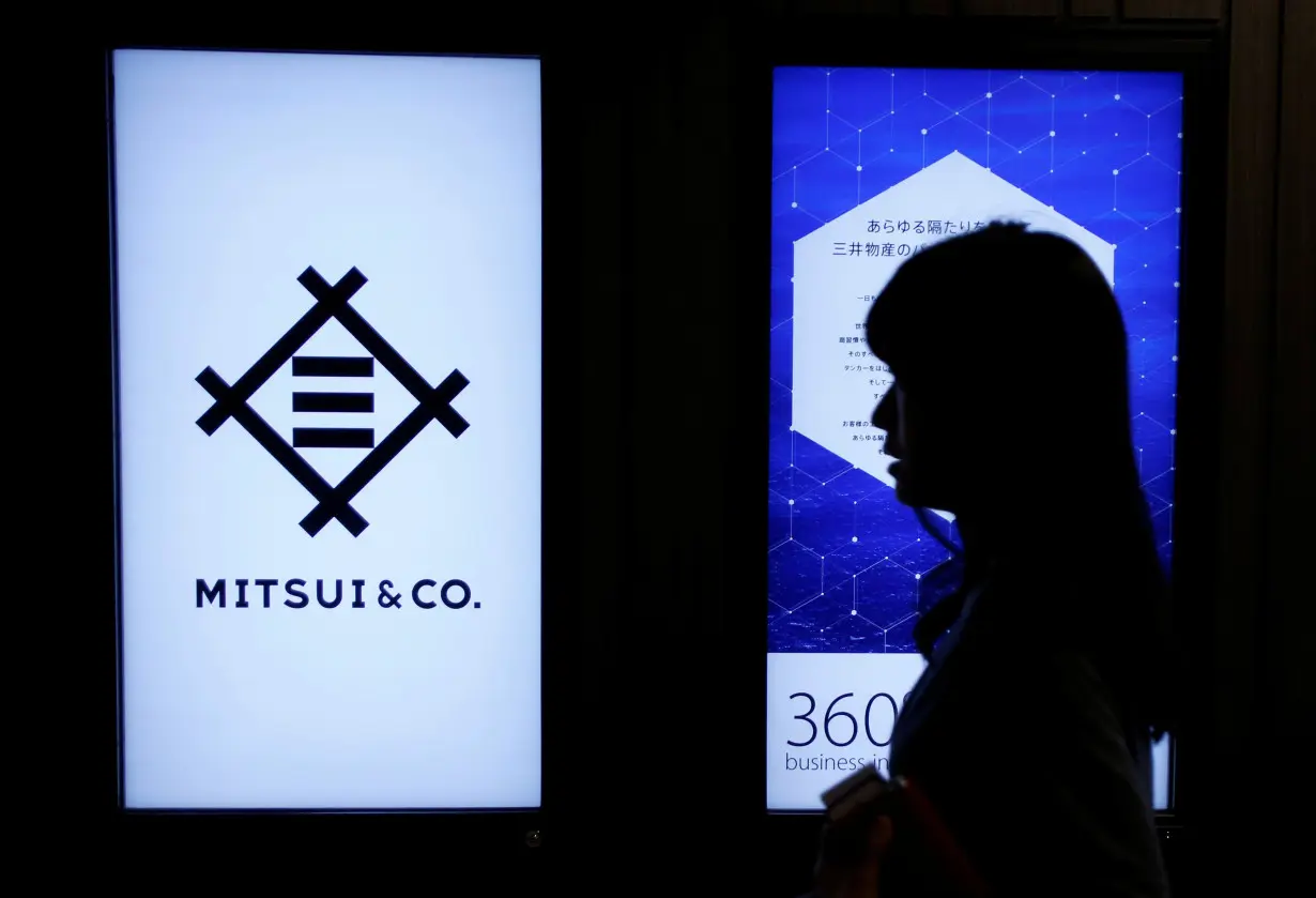 Woman walks past the logo of Japanese trading company Mitsui & Co. in Tokyo