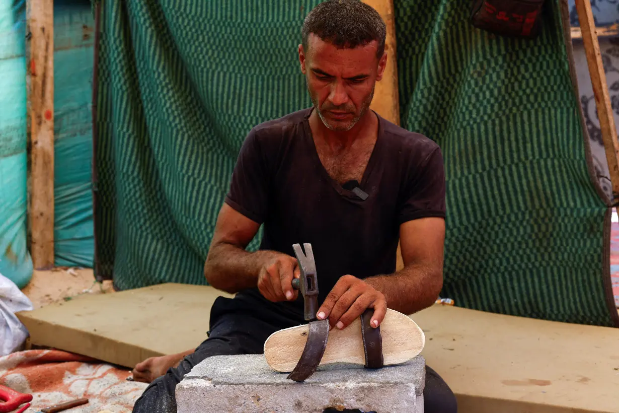 Carpenter carves out wooden footwear for children in Gaza