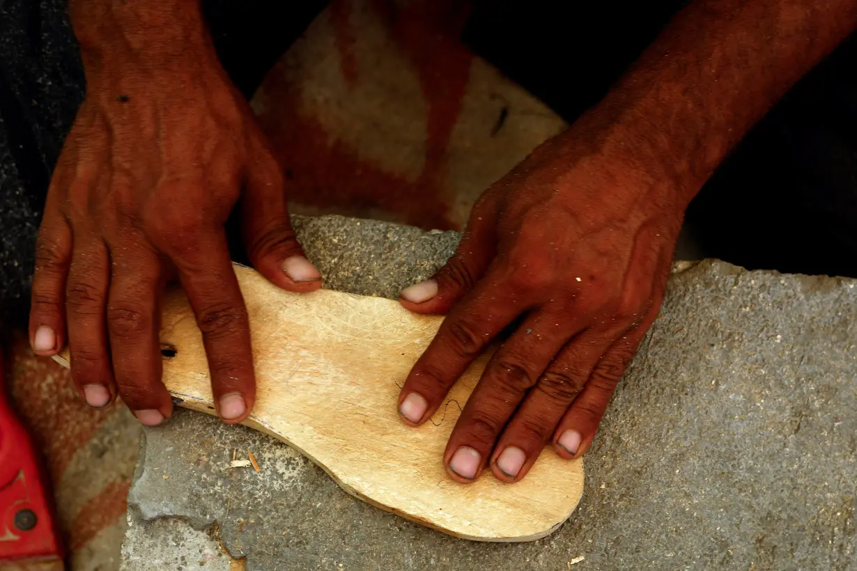 Gaza carpenter crafts wooden sandals for daughters as war rages