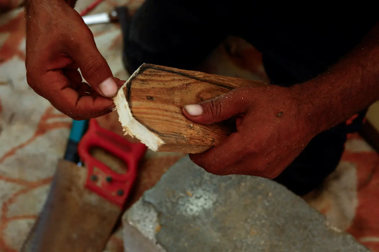 Gaza carpenter crafts wooden sandals for daughters as war rages