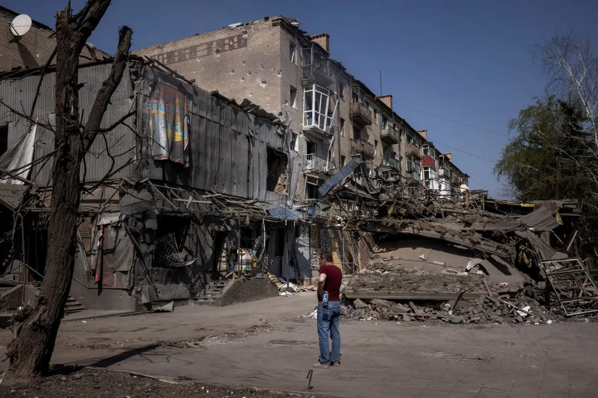 A man looks at the damage from shelling opposite the train station in Kostiantynivka