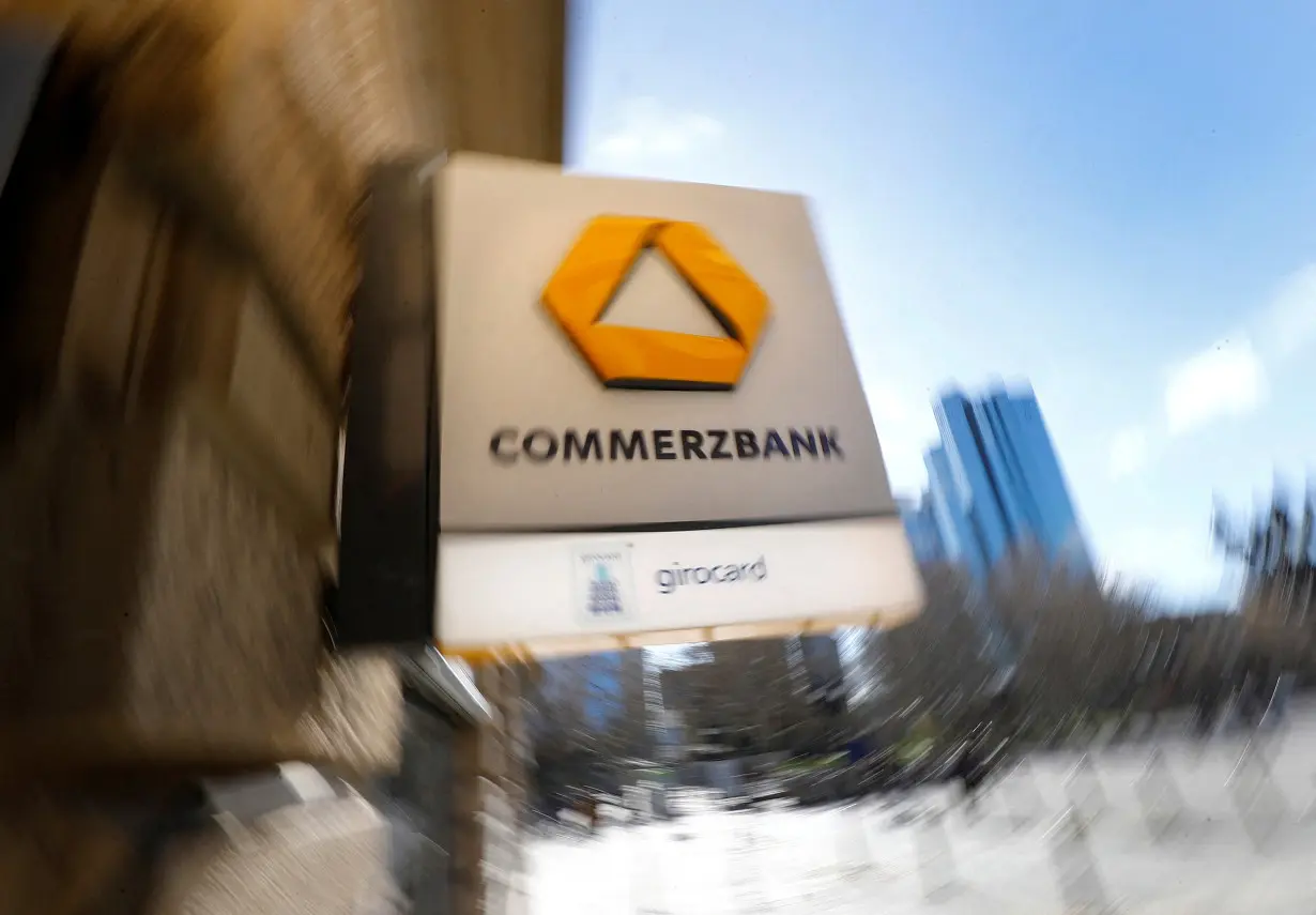 FILE PHOTO: A sign for an ATM of Commerzbank is seen next to the headquarters of Deutsche Bank (R) in Frankfurt