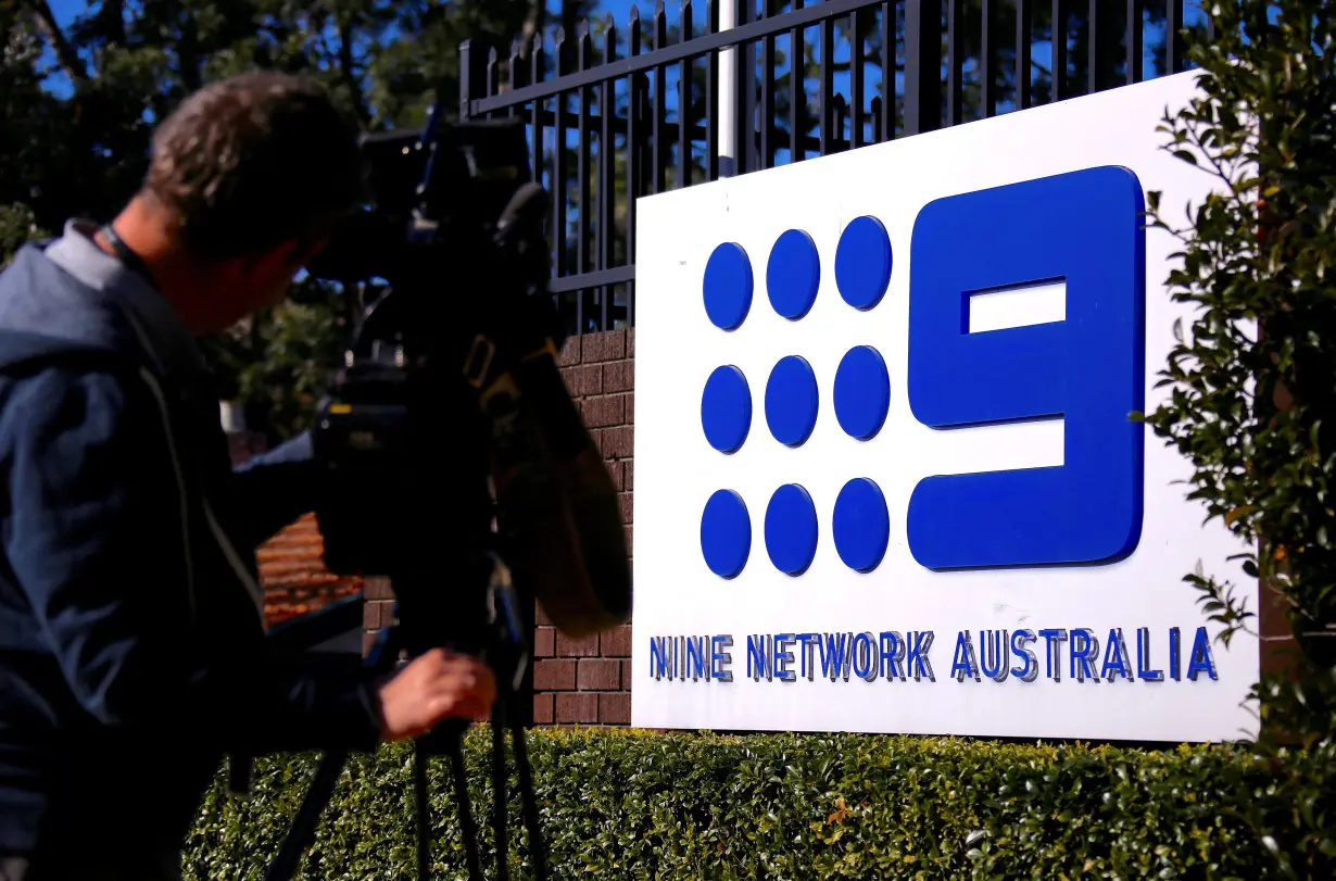 FILE PHOTO: A television cameraman films the logo of Nine Entertainment Co Holdings Ltd on display outside their Sydney headquarters