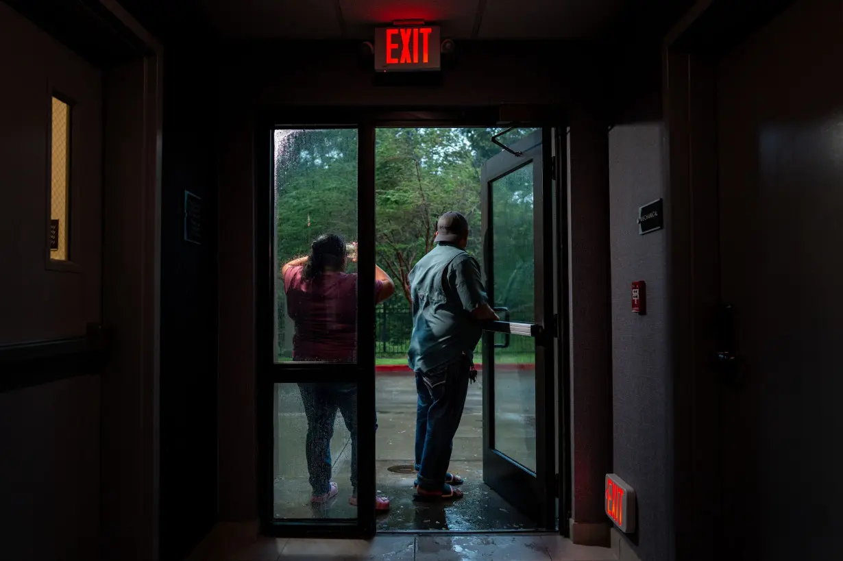 A family watches Hurricane Francine from their hotel in Houma, Louisiana, on September 11.