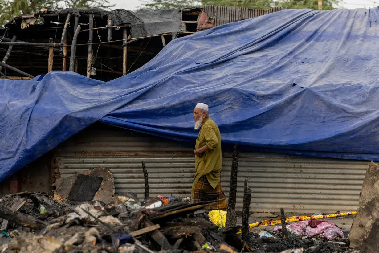 FILE PHOTO: A Rohingya refugee walks past a half-burnt mosque after a fire destroyed a Rohingya refugee camp on Saturday night, in New Delhi