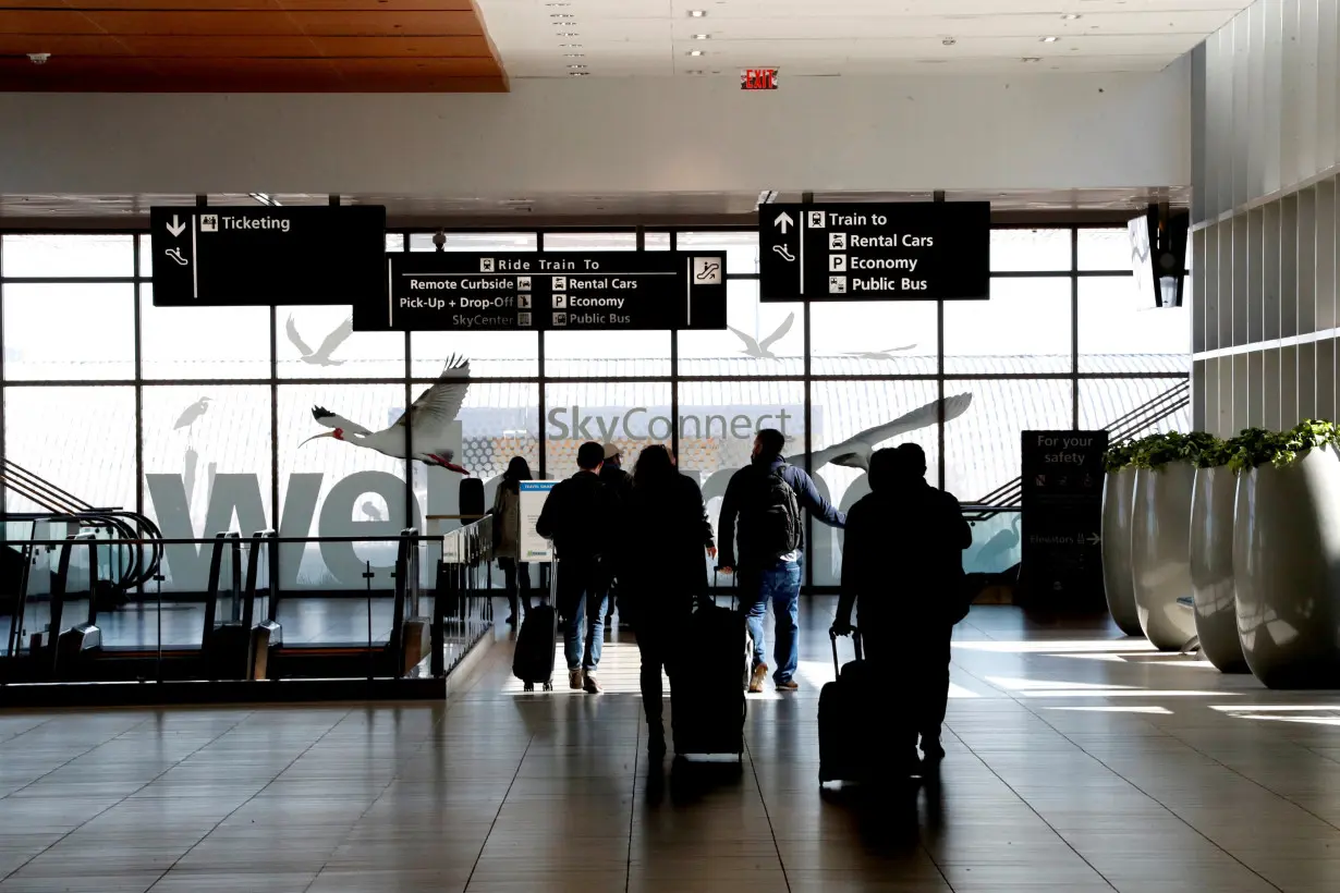 Airline passengers walk inside the Tampa International Airport