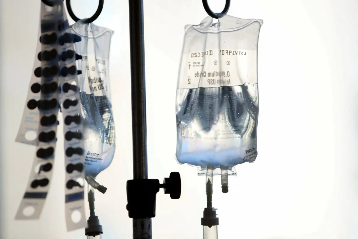 Intravenous bags hang above young cancer patients at Rady's Children Hospital as they participate in decorating golden capes to wear as superheroes as part of Childhood Cancer Month in San Diego, California