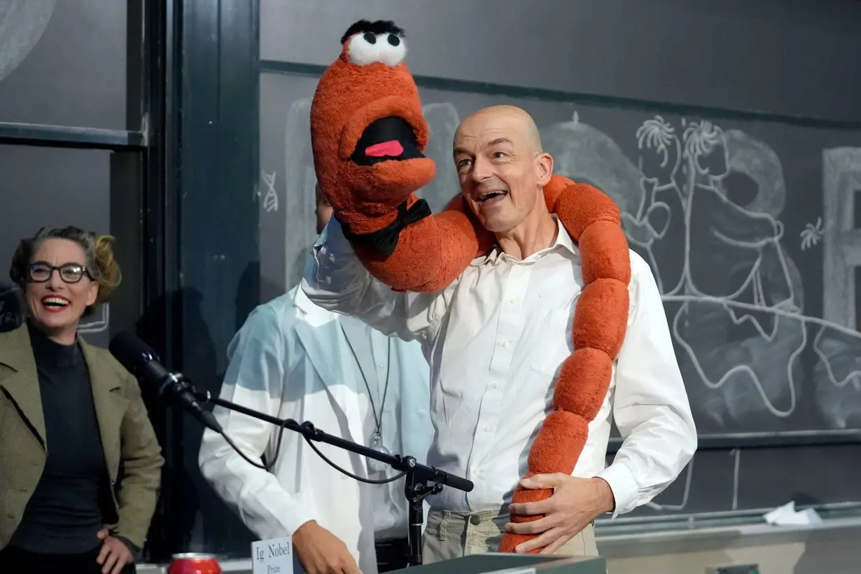 Professor Sander Woutersen, right, displays an oversized stuffed worm while accepting a shared Ig Nobel Prize in chemistry for research using chromatography to separate drunk and sober worms.