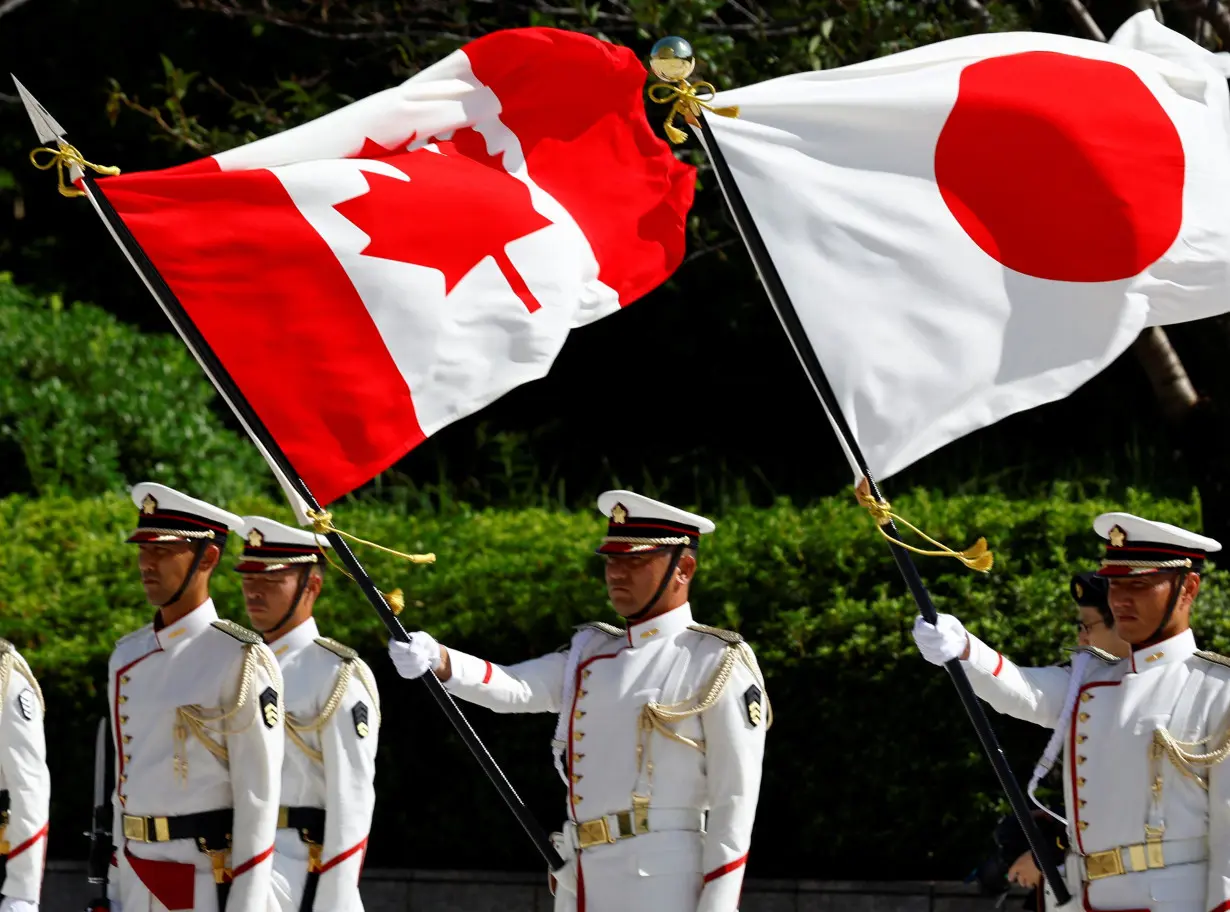 Japanese honour guards hold the national flags of Canada and Japan during a ceremony for Canadian Defence Minister Bill Blair at the Ministry of Defense in Tokyo