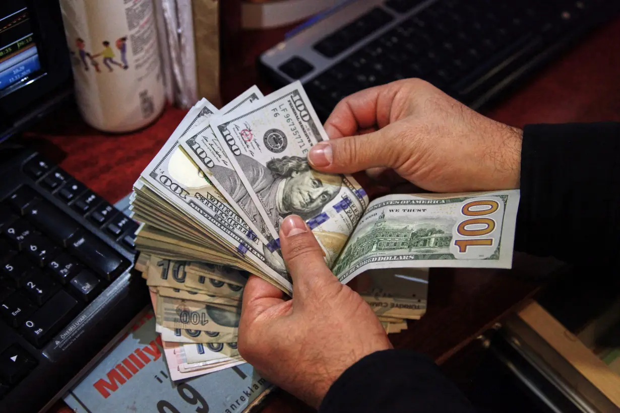 A money changer counts U.S. dollar banknotes at a currency exchange office in Ankara