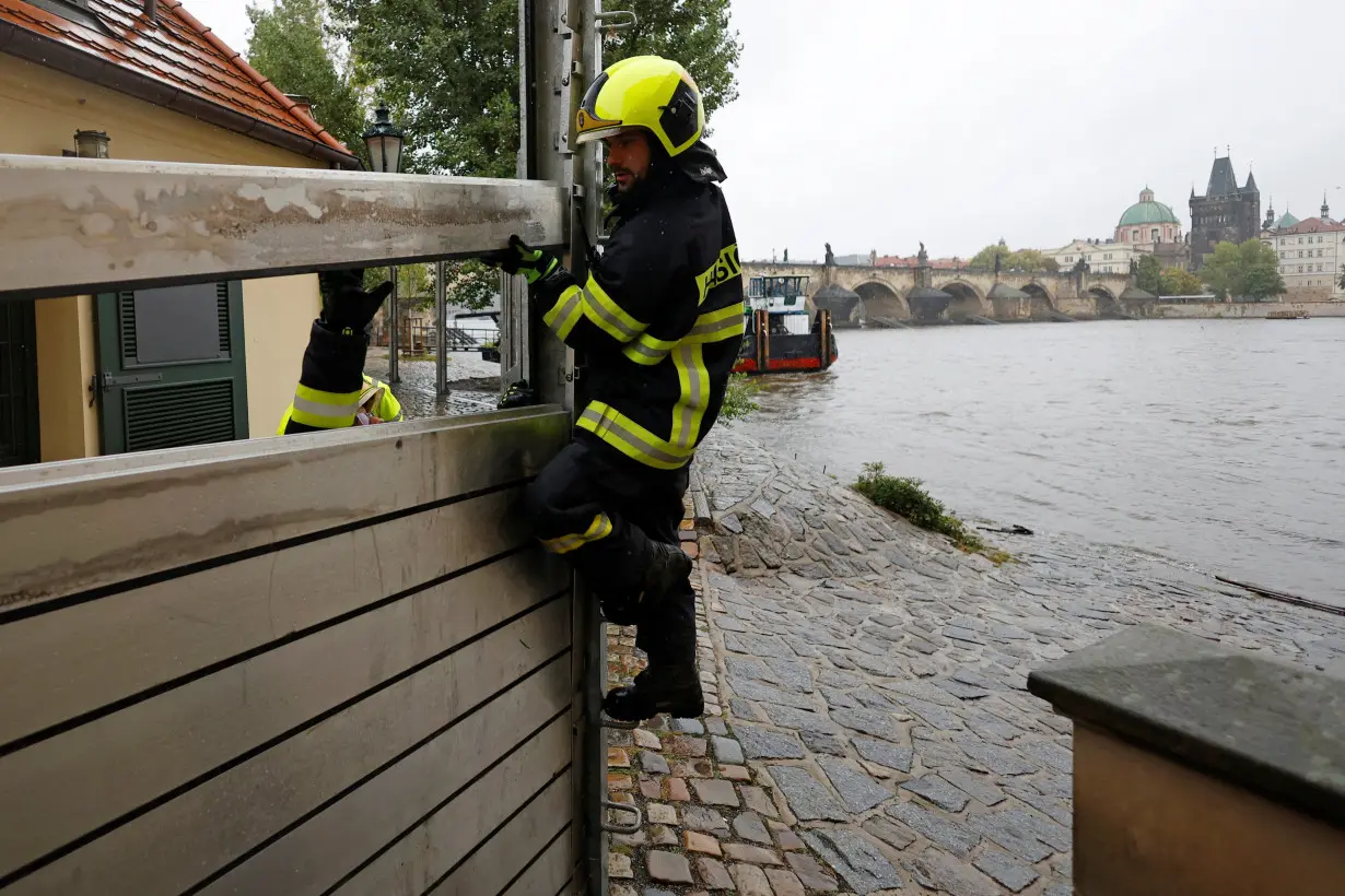 Firefighters assemble a water barrier in Prague