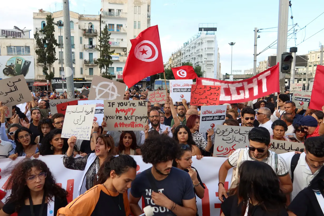 Demonstrators hold flags and signs during a protest against President Kais Saied in Tunis