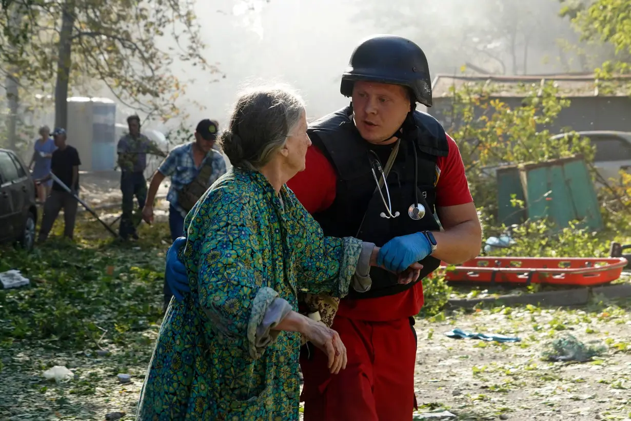 An elderly woman is assisted after a Russian aerial bomb struck a multi-story residential building in Kharkiv, Ukraine, Sunday Sept. 15.