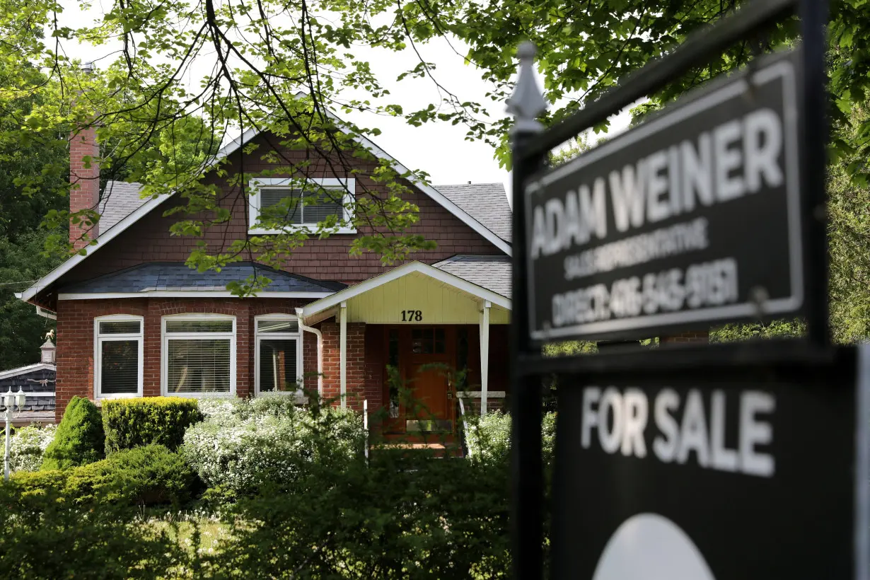 FILE PHOTO: A realtor's sign stands outside a house for sale in Toronto