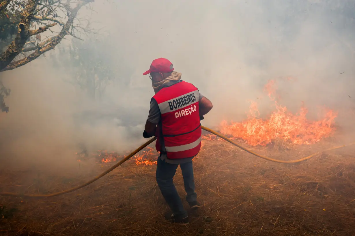 Firefighters extinguish a wildfire in Penalva do Castelo