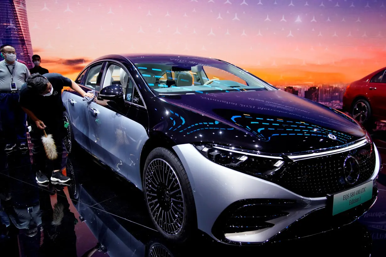 FILE PHOTO: A staff member cleans a Mercedes-Benz EQS 580 4MATIC electric vehicle during a media day for the Auto Shanghai show