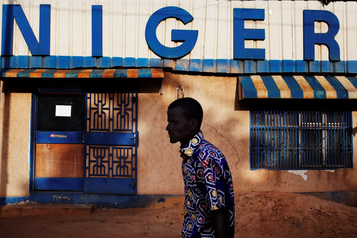 FILE PHOTO: A man walks past a sign reading 