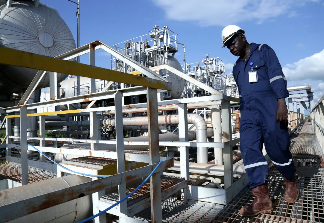 A worker walks by an oil well at the Toma South oil field to Heglig, in Ruweng State