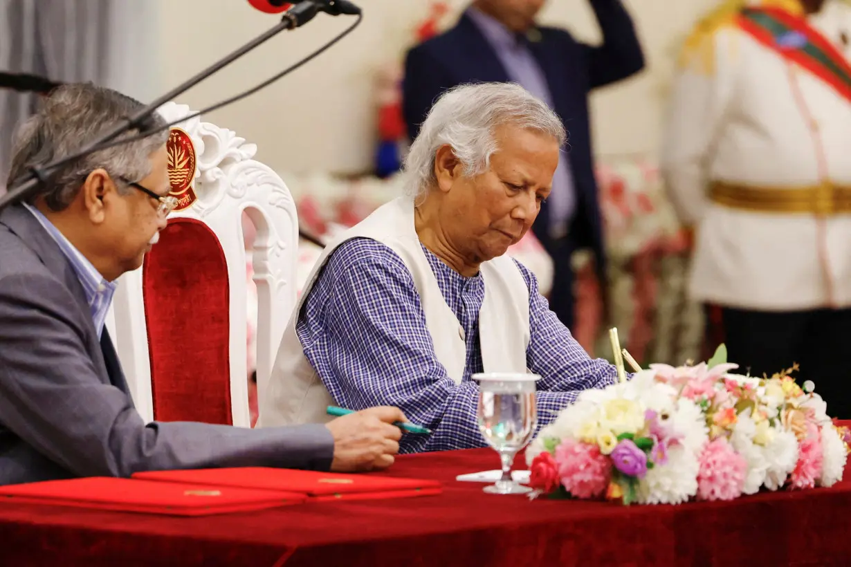 FILE PHOTO: Nobel laureate Muhammad Yunus signs the oath book as the country's head of the interim government in Bangladesh at the Bangabhaban, in Dhaka