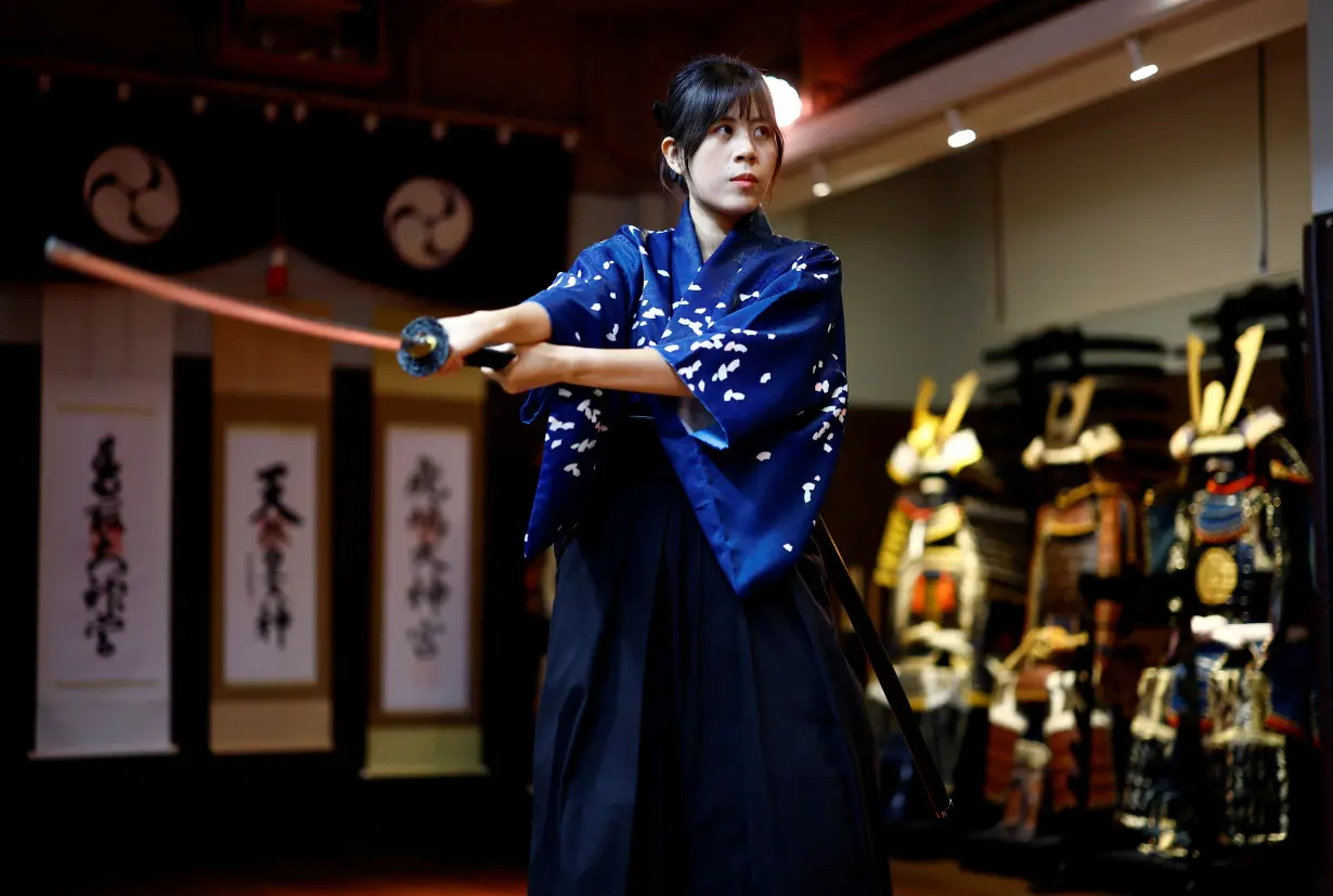 Sophie Yick, a tourist from Hong Kong, wearing traditional clothing takes part in a Samurai experience at Samurai Theater Tokyo